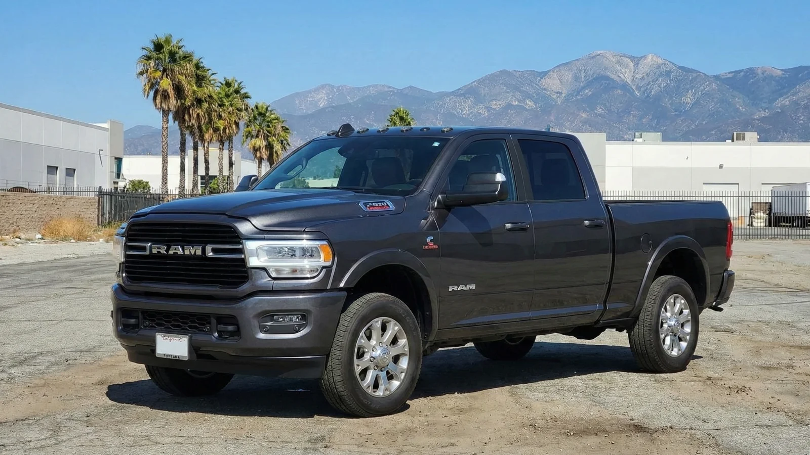 Gray 2026 Ram 2500 pickup truck with palm trees and California mountains
