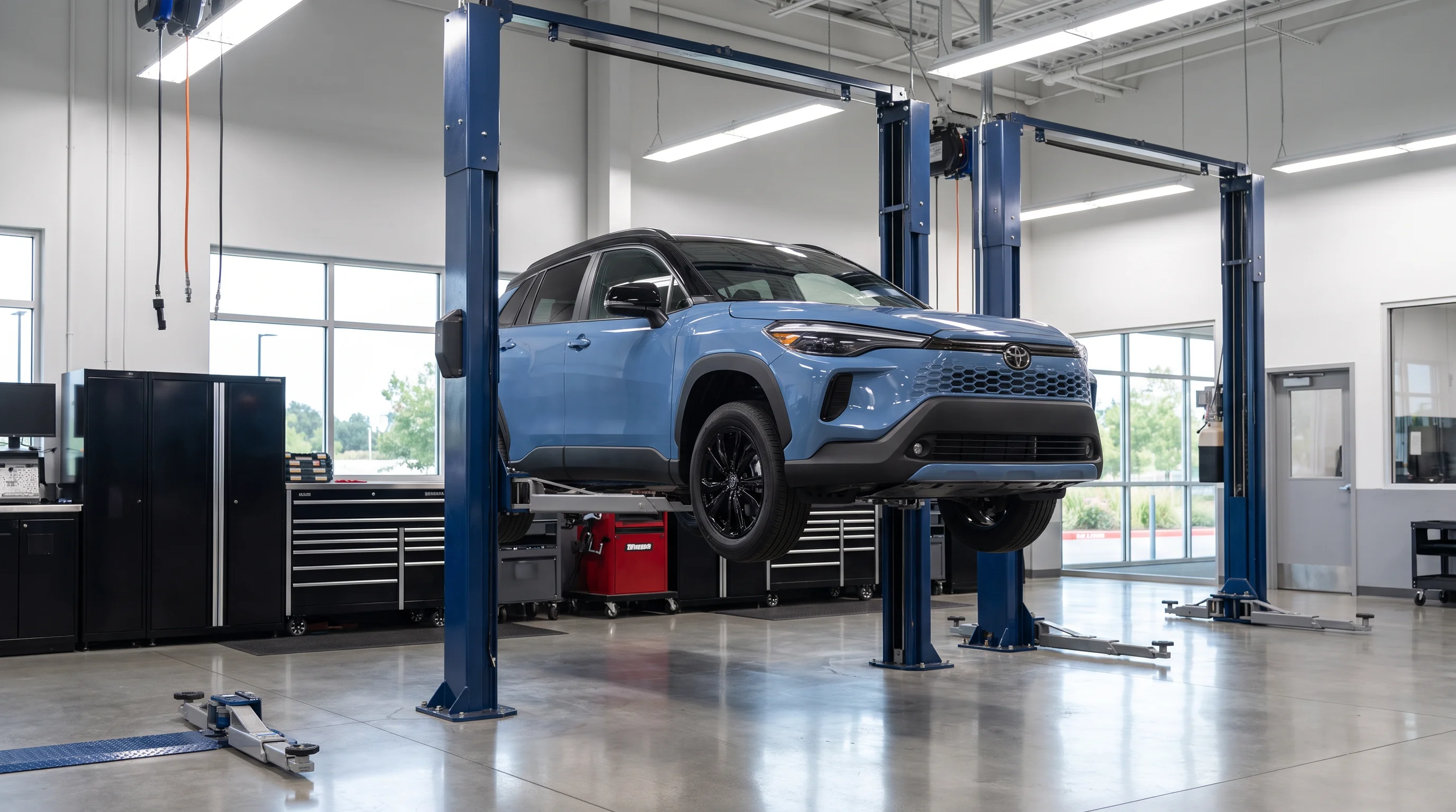 Technician performing vehicle service in a dealership service bay